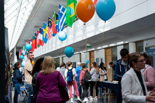 image of people standing on the concourse of ATU Sligo with flags in the background
